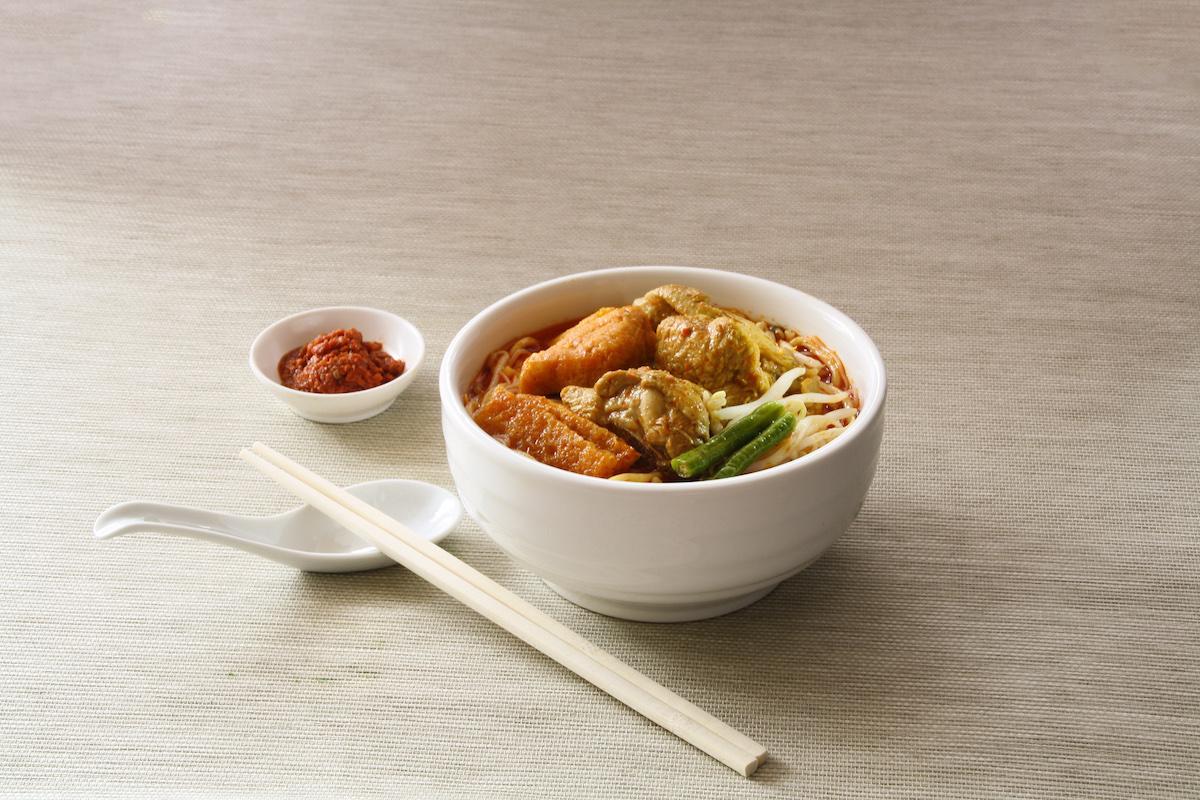 Noodle soup in bowl with sticks and spices